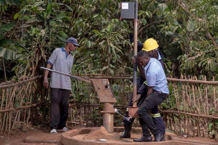 Mr. Niyonteze Sepiriyano, a resident of Ssenda Kakindu in Mityana district observes technicians from Whave Solutions as they carry out repairs on a borehole.